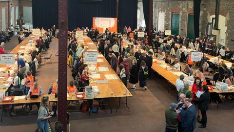 People counting votes at tables