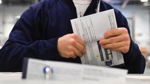 An election worker demonstrating how ballots are received in Philadelphia, Pennsylvania. 