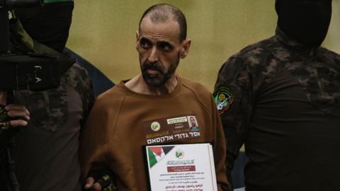 Eli Sharabi stood between two Hamas soldiers looking thin