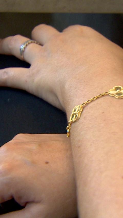 A close shot of a woman's hand with a gold bracelet
