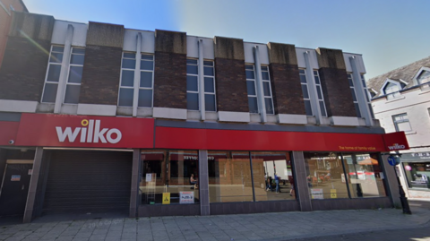 Shutters down on a Wilko's store with blue sky above