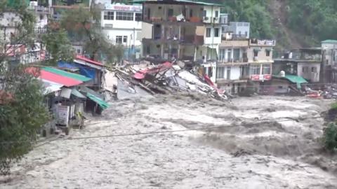 Gushing water sweeping away everything in its way and damaging homes and shops in a hilly city in India's Uttarakhand