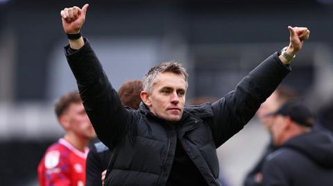 Ipswich Town head coach Kieran McKenna raises both his arms after a victory