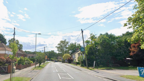 A Google street view of a residential road on a sunny day