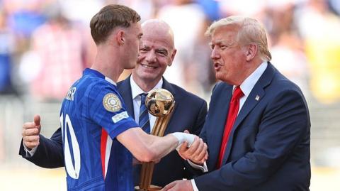 US President Donald Trump and Fifa president Gianni Infantino give Chelsea's Cole Palmer his player of the tournament trophy at the Club World Cup