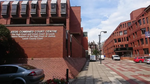 Exterior view of Leeds Combined Court Building, a red brick building with rectangular windows.