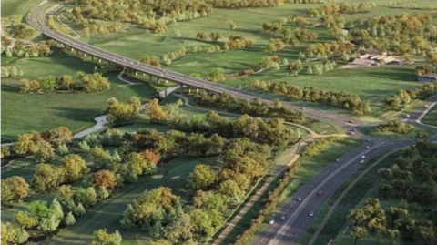 A dual carriageway and roundabout runs through fields and trees in Norfolk.