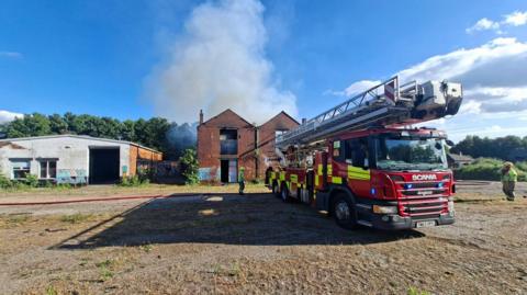A fire engine in front of a derelict building