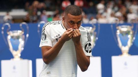 Kylian Mbappe kisses the Real Madrid shirt