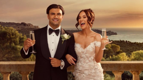 The reality stars on their wedding day, standing on a balcony, holding a glass of champagne