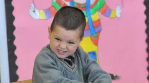 A young child in a school uniform