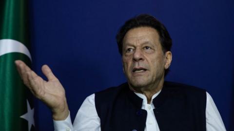 Imran Khan in front of a Pakistani flag