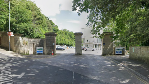 The entrance to a car park with pillars outside