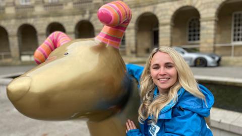 Sophie Wheeldon, from the Blythe House Hospice, with one of the sculptures outside the Crescent