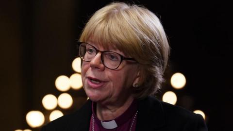Dame Sarah Mullally, who has a blonde bob hairstyle with a fringe and wears glasses with a dark frame, is pictured speaking at a previous event at Chapter House in Canterbury Cathedral