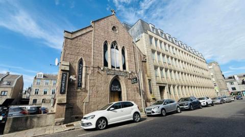 Buildings on Dee Street in Aberdeen with cars in the street