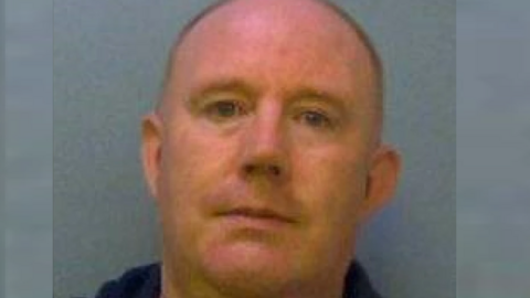 A police custody photo of Nicholas Brock, who is clean-shaven with a closely shaved head