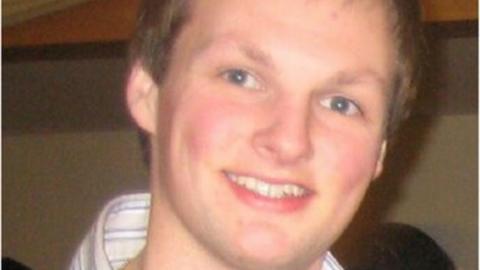 Shane O'Farrell has short blonde hair and blue eyes. In the close up picture he appears to be wearing a white stripped shirt.