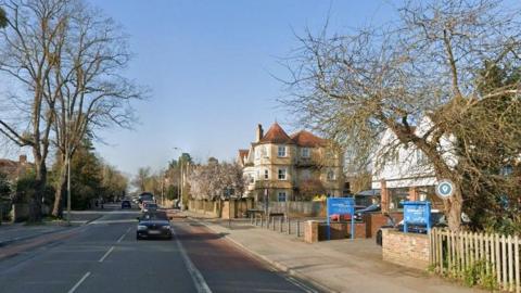 Google Street View of a main road in Oxford, large houses on one side, bus lanes on both sides.