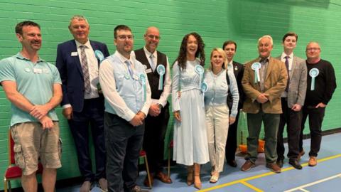 Reform UK candidates at the Derbyshire County Council election count in a sports hall 