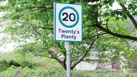 a road sign showing the Twenty's Plenty speed limit