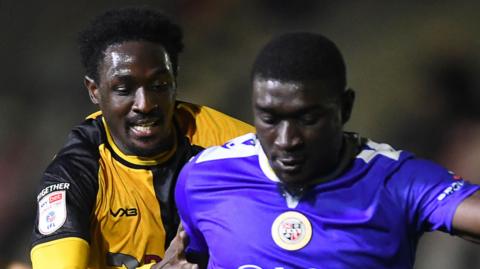 Nathan Opoku of Newport County is challenged by Damola Ajayi of Bromley