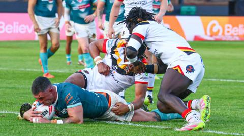 Curtis Sironen (left) has the ball down on the tryline for St Helens with two Bradford defenders on top of him