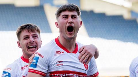 Hull Kingston Rovers forward Tom Whitehead shouts in celebration after scoring a try against Huddersfield Giants, with grinning team-mate Tom Davies behind him and grabbing his shoulder.