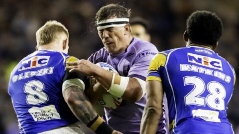 Hull KR's Jai Whitbread is tackled by Leeds' Mikolaj Oledzki