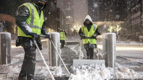 Workers clear snow in New York City
