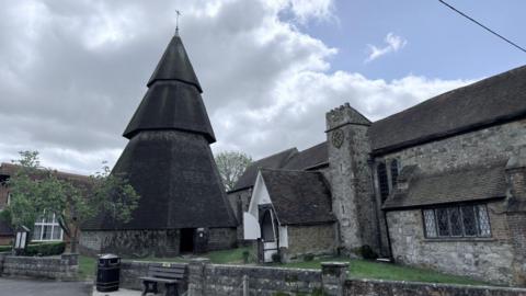 A church building with it steeple built next door to it.