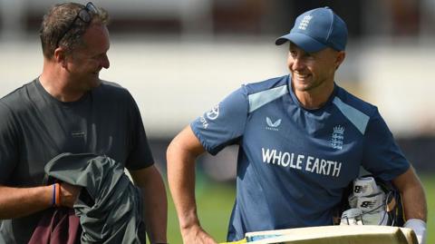 England Test captain Joe Root holding his bat in the air