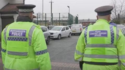 PC and PCSO in yellow, high-vis jackets on patrol