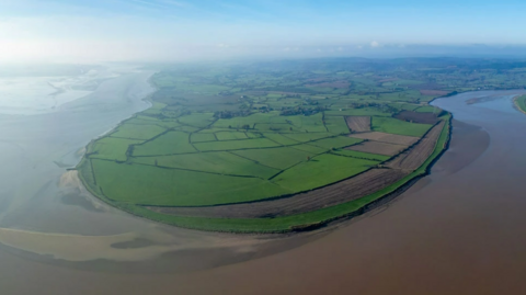 Aerial view of a farmland peninsula, with the brown-coloured River Severn curving around its edge.