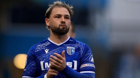 Gillingham captain Bradley Dack applauds the fans