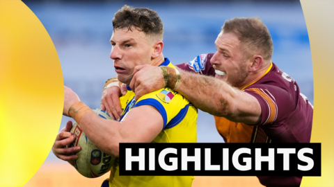 George Williams of Warrington is tackled by Tom Burgess of Huddersfield