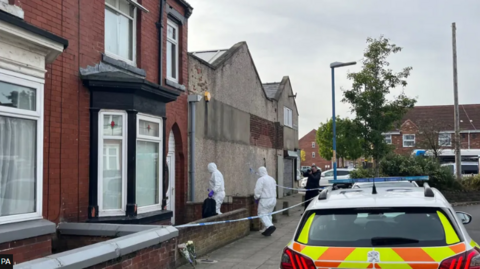 Police officers in white forensic suits 