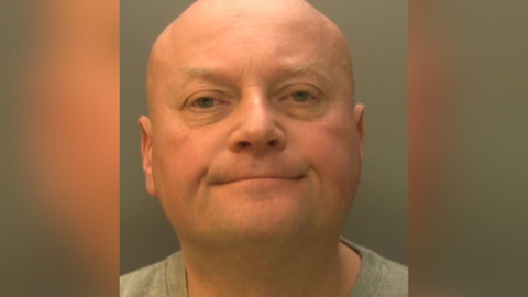 A mugshot bald man