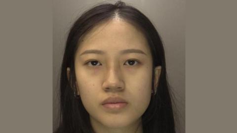 A mugshot of Jia Xin Teo with a brown background 