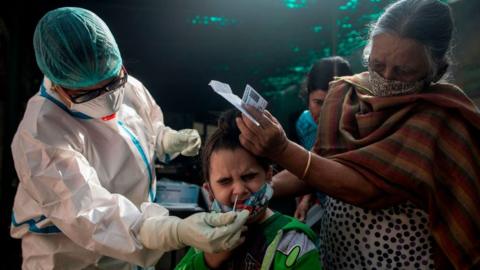 A medical worker collects a swab sample for a Rapid Antigen Test (RAT) for the Covid-19 coronavirus at a dispensary in New Delhi on November 10, 2020.