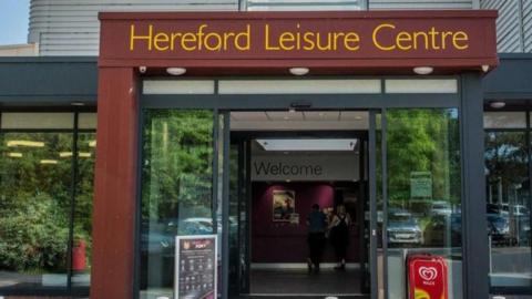 Entrance to Hereford Leisure Centre, with the name in yellow letters above the door.