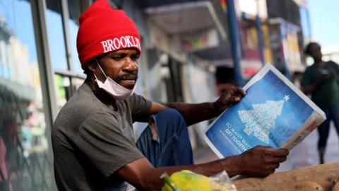Man reads local Barbadian newspaper