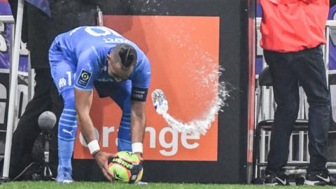 Dimitri Payet is hit by a bottle as he places the ball for a corner kick