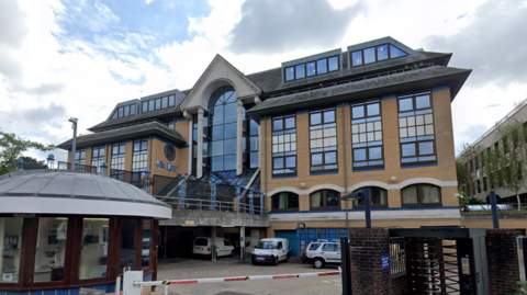 A large office building with a car park in front