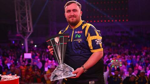  Luke Littler poses with the trophy following the final with Nathan Aspinall 