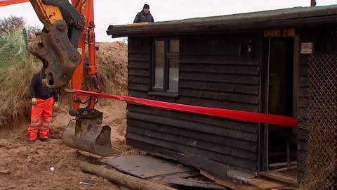 A tractor and winch are used again to move the property further inland after severe coastal erosion.
