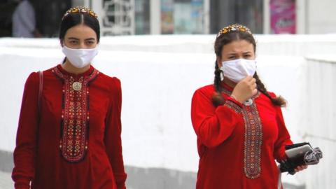 Turkmen women wearing face masks walk in Ashgabat on July 13, 2020. - Reclusive Turkmenistan on July 13 recommended that residents wear masks because of "dust" even as the government insists the country is coronavirus-free.