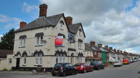 An external view of the Duke of Edinburgh pub showing a for sale sign