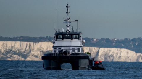 A British Border Force vessel picks up an inflatable dinghy carrying migrants in the English Channel