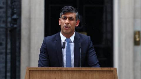 rishi sunak standing at a podium outside number 10 downing street